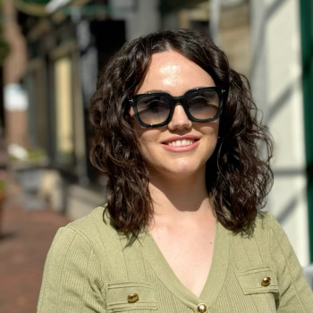 Gewinnerin testet ihre neue Sonnenbrille bei sonnigem Wetter vor dem Optikgeschäft in Lingen